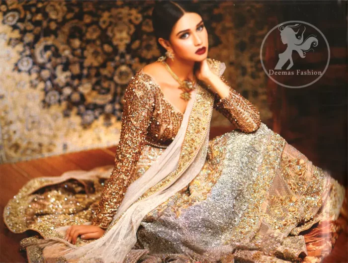 Ivory white and fawn bridal dress for the Walima function.Fully embroidered full-sleeved blouse. Lehenga features stunning embellishments. An embellished border is implemented on four sides of the dupatta. Crystal stones are crafted all over the dupatta. Ivory White Fawn Bridal Blouse And Lehenga.