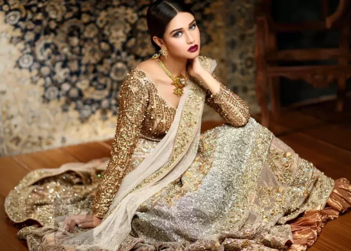 Ivory white and fawn bridal dress for the Walima function.Fully embroidered full-sleeved blouse. Lehenga features stunning embellishments. An embellished border is implemented on four sides of the dupatta. Crystal stones are crafted all over the dupatta. Ivory White Fawn Bridal Blouse And Lehenga.