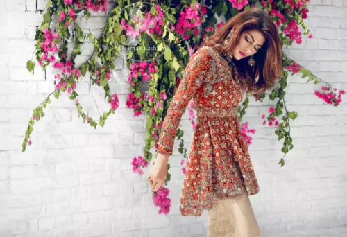 Rust Short Back Trail Frock has been adorned with an embellished neckline. Small motifs spray scattered all over the front