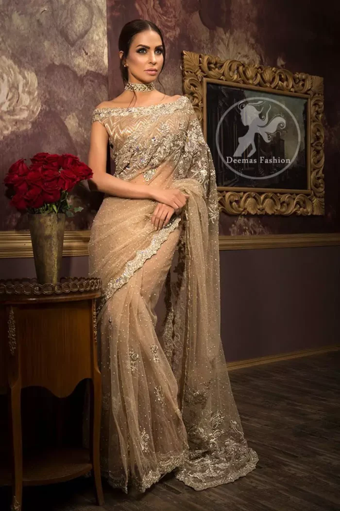 Banarsi jamawar blouse contains embroidered border on the neckline. Net saree contains flourishing embellishments all around the edges. Stones spray scattered all over the saree. Large motif implemented at the centre of saree.