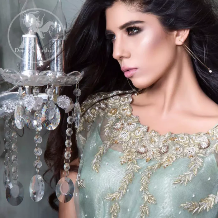 The shirt has been adorned with an embellished neckline. A large work border is implemented at the bottom of the shirt. The shirt comes with embroidered waist belt. Stones spray scattered all over the shirt. Trousers contain embroidered borders at the bottom. Work includes kora, dabka, stones, sequins, beads, silk threads, and Swarovski crystals.