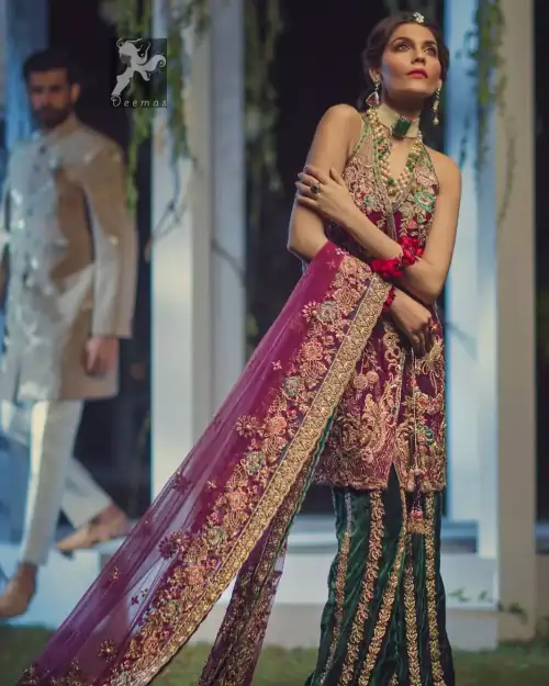 Claret colour peplum having halter neck design with bottle green loose trousers and heavy embellished Dupatta