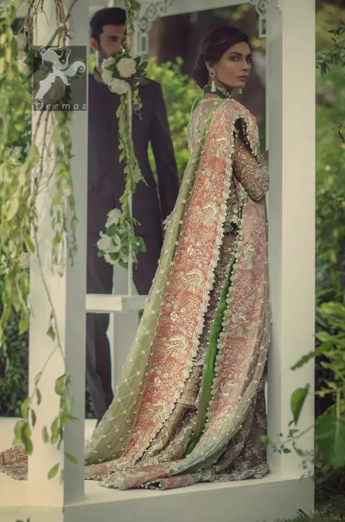 Fawn short length peplum made with net having embellished belt on waist. Large embellished border having peach appliqued on dupatta. Dupatta is adorned with rectangular shapes of embellishment small motifs all over it. Fitted lehenga having extra layer above the knees.