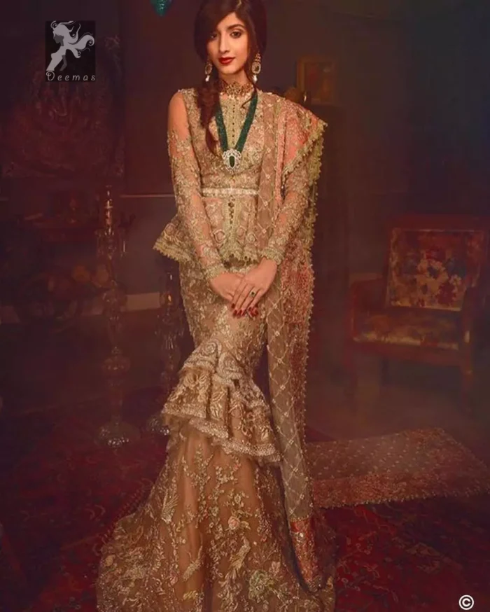Fawn short length peplum made with net having embellished belt on waist. Large embellished border having peach appliqued on dupatta. Dupatta is adorned with rectangular shapes of embellishment small motifs all over it. Fitted lehenga having extra layer above the knees.