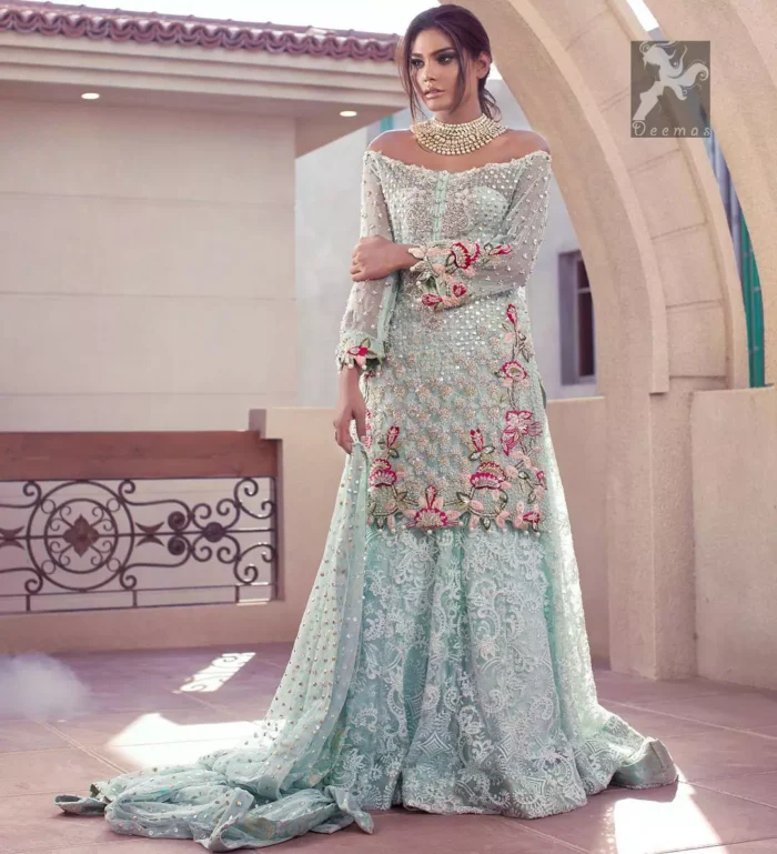 Sweetheart neckline pure crinkle chiffon shirt adorned with embellishment. Embellishment includes majorly light golden, silver, shocking pink and mehndi green shades. Shirt comes with embroidered sharara and net dupatta.