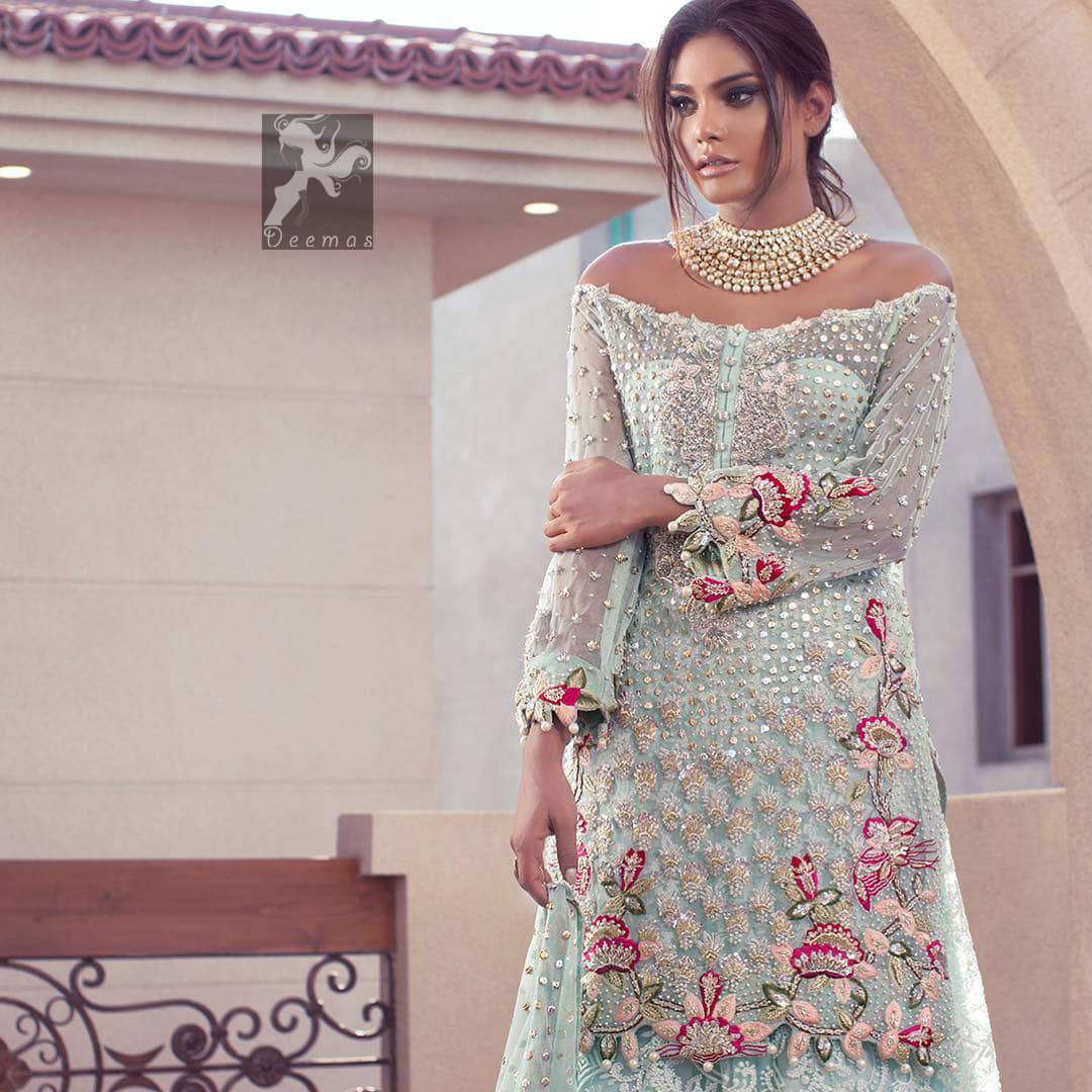 Sweetheart neckline pure crinkle chiffon shirt adorned with embellishment. Embellishment includes majorly light golden, silver, shocking pink and mehndi green shades. Shirt comes with embroidered sharara and net dupatta.