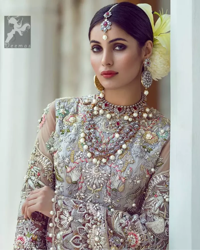 Ivory white long fitted bridal maxi. Maxi adorned with colorful embellishment using appliques and threads. Bridal maxi comes with two tones dupatta having peach and ivory white shades.