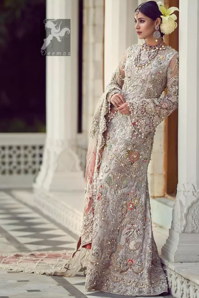 Ivory white long fitted bridal maxi. Maxi adorned with colorful embellishment using appliques and threads. Bridal maxi comes with two tones dupatta having peach and ivory white shades.