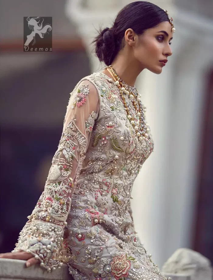 Ivory white long fitted bridal maxi. Maxi adorned with colorful embellishment using appliques and threads. Bridal maxi comes with two tones dupatta having peach and ivory white shades.
