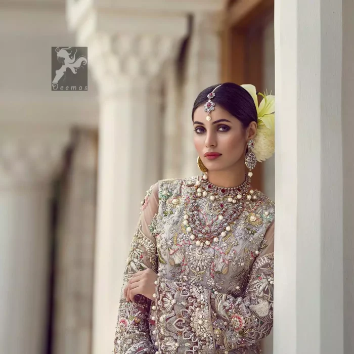 Ivory white long fitted bridal maxi. Maxi adorned with colorful embellishment using appliques and threads. Bridal maxi comes with two tones dupatta having peach and ivory white shades.