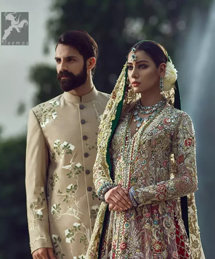 Light fawn pure crinkle chiffon front slits gown adorned with beautiful colorful embellishment. Red lehengha adorned with embellishment all over it. Light pistachio dupatta having embellished border on sides and motif spray all over it and finished with piping.
