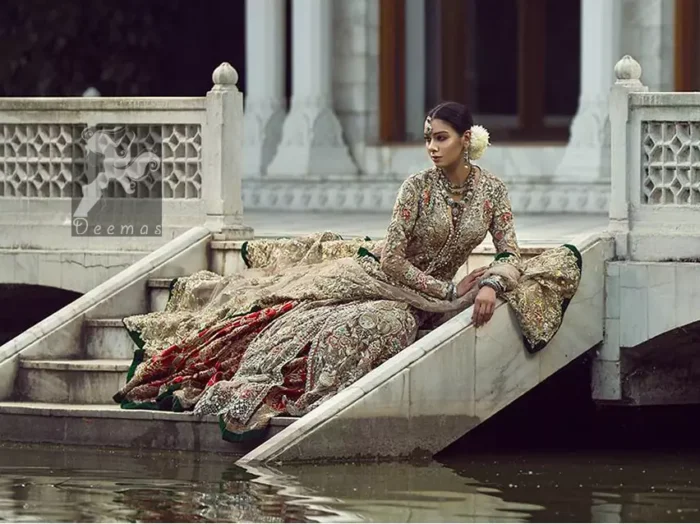 Light fawn pure crinkle chiffon front slits gown adorned with beautiful colorful embellishment. Red lehengha adorned with embellishment all over it. Light pistachio dupatta having embellished border on sides and motif spray all over it and finished with piping.