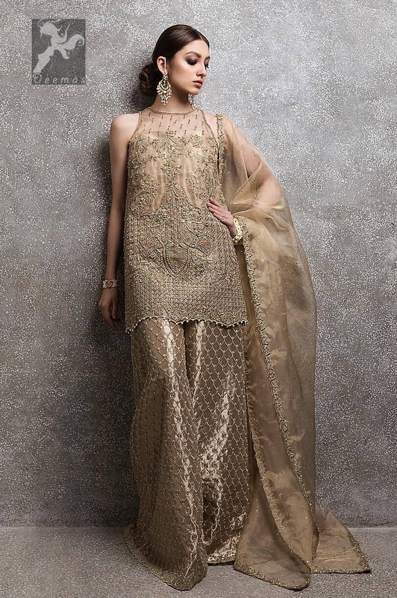 Light golden brown pure organza short shirt having halterneck design. Shirt has been embellished with antique and different shades of embellishment. Small embellishment border on dupatta. Sharara is adorned with embellishment all over it.