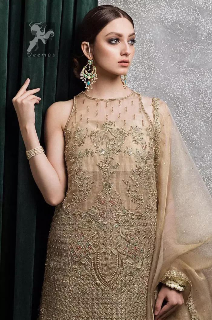 Light golden brown pure organza short shirt having halterneck design. Shirt has been embellished with antique and different shades of embellishment. Small embellishment border on dupatta. Sharara is adorned with embellishment all over it.