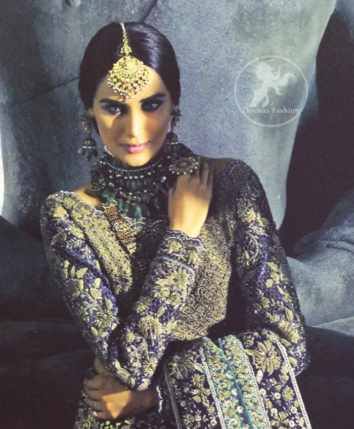 Violet Blue Blouse is of velvet fabric. It is heavy embellished full sleeves blouse featuring antique and golden shaded kora, dabka, resham, naqshi, pearls, crystals and swarovski. Blouse is fully scalloped with blue bayoux resham outline. Sleeves are adorned with floral work and sprinkling sequins/naqshi on it, while bodice having criss cross pattern all over it. It comes with raw silk lehengha which is adorned with block printing and the touch of hand embellishment. It is artistically coordinated with blue bayoux dupatta which is adorned with fully embellished appliqued borders. Borders are accompanied by delicate work along its internal sides. There are four embellished heavy flowers on corners and small floral pattern all over it.
