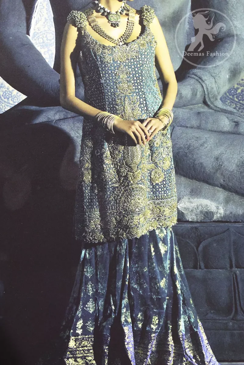 Bluish Slate Grey heavily embellished shirt is decorated with dull golden, champagne and antique shades of embroidery. The shoulders is embedded with beautiful antique 3D floral work. Skirt having embellished border on the hemline. The velvety lehengha is adorned with block print floral pattern all over and border on edges.