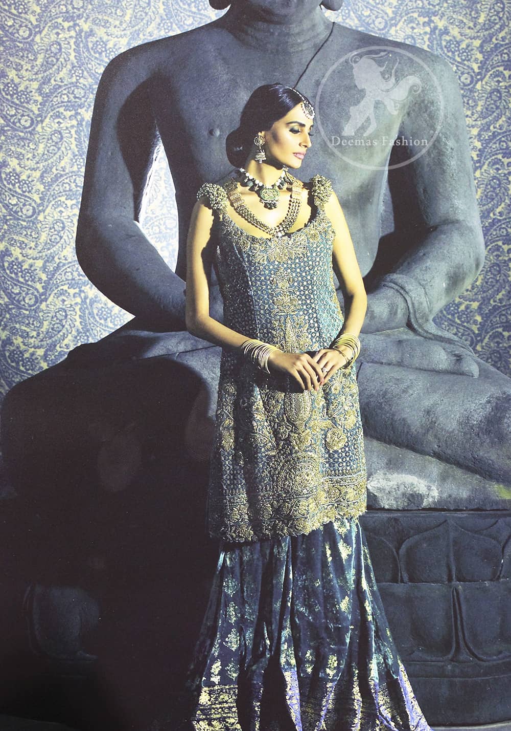 Bluish Slate Grey heavily embellished shirt is decorated with dull golden, champagne and antique shades of embroidery. The shoulders is embedded with beautiful antique 3D floral work. Skirt having embellished border on the hemline. The velvety lehengha is adorned with block print floral pattern all over and border on edges.