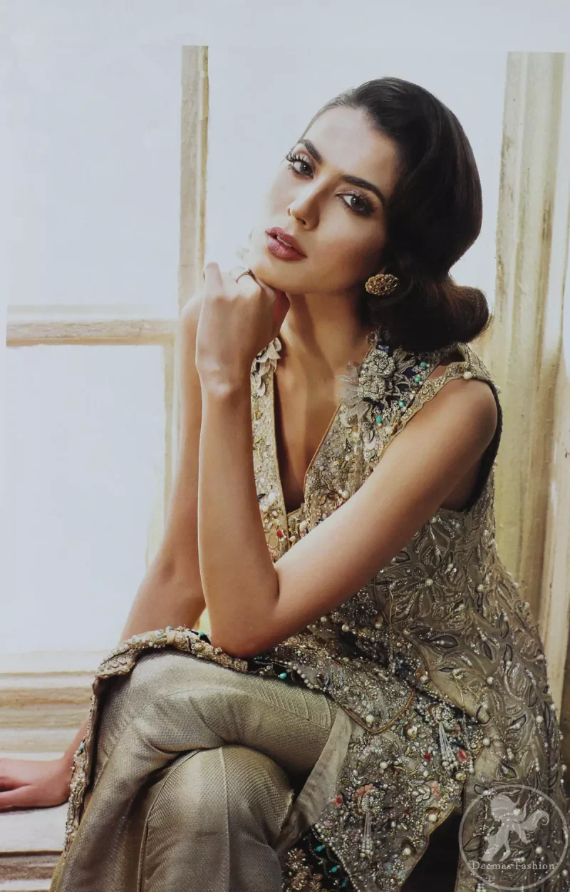 Grey olive floral embroidered high and low front open short frock. Frock is finessed with kora, dabka, pearls, sequins and swarovsky. The daman of the frock is beautifully enhanced with scalloped border and silhouettes. This shirt is adorned with 3D floral embroidered motifs having V shaped neckline. Top is coordinated with pajama having embroidered motifs.