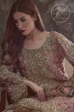 Copper Rose Shirt Vanilla Trousers. It is adorned with a criss-cross design. This shirt is meticulously highlighted with dull golden and antique shaded kora, dabka, tilla, sequins and pearls.