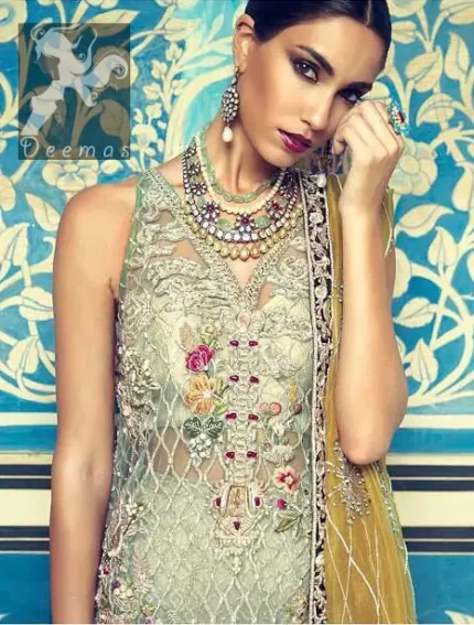 This shirt is decorated with resham threads, kora, dabka, tilla, sequins and pearls. The shirt is beautifully decorated with self embroidered criss cross pattern. It is further enhanced with embroidered scalloped border which adds to the look. It comes with brocade bell shaped trousers. It is beautifully coordinated with organza mehndi colored dupatta, allured with four sided embellished appliqued border.