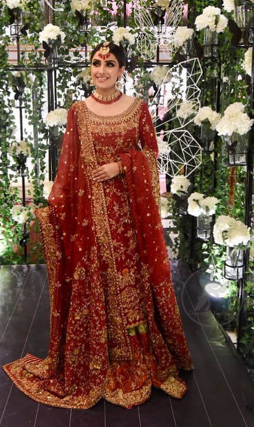 This dress is beautifully sculptured with floral embroidery. It is allured with red, dull golden, champagne and antique shaded kora dabka, tilla, sequins and pearls. It is adorned with beautiful U-shaped embellished neckline which adds to the look.It is artistically coordinated with rust embellished lehenga. It comes with burnt red dupatta which has heavy work on pallu and four sided embroidered border. Dupatta is sprinkled with small sized floral motifs all over.