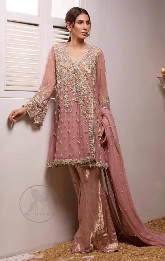 This outstanding copper rust angrakha meticulously highlighted with dull golden, tea pink and silver shaded kora, dabka , tilla, sequins and pearls. This dress is beautifully adorned with floral embroidery. It is decorated with small and large sized floral motifs. It is also embelished with beautiful tassels which adds to the look.It comes with brocade gharara pants. It is artistically coordinated with chiffon dupatta having sprinkled sequins all over it.