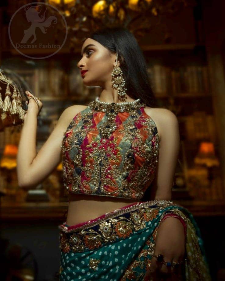 This outfit is a timeless beauty. It is heavily embellished with antique gold kora, dabka, tilla, sequins and swarovski crystals. This exquisite halter neckline blouse is fully decorated with floral motifs patterns all over it. Applique waist belt is decorated with gota and thread embroidery.It comes with embellished lehengha. This Outfit is beautifully coordinated with lime yellow dupatta with heavy embroidered borders.