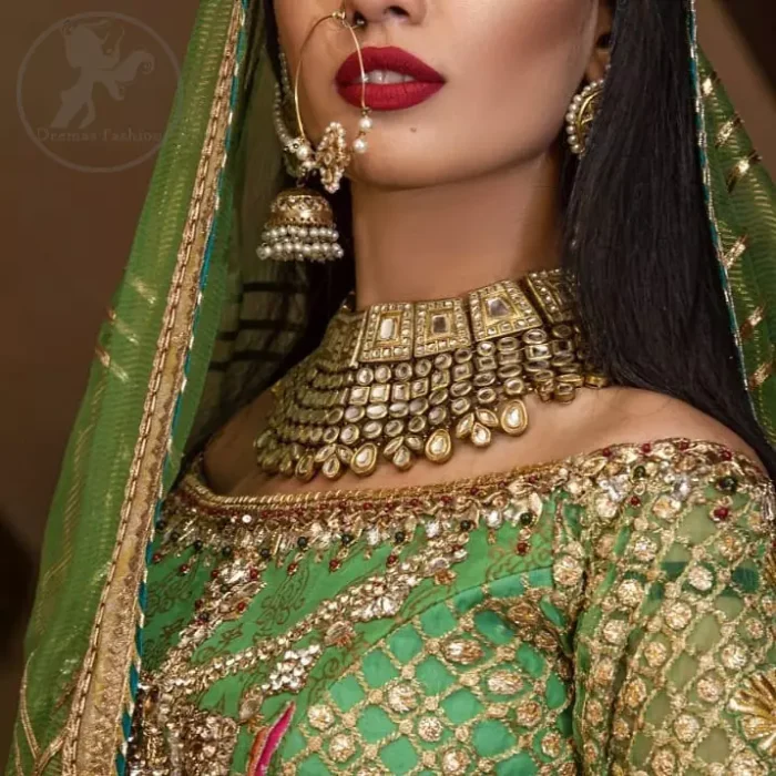 This outfit is embellished with gotta lace. It is meticulously highlighted with kora dabka, tilla, sequins and pearls. Sleeves are adorned with gotta lace in criss cross pattern. Boat-shaped neckline ornamented with floral motifs. It comes with hippie green lehenga adorned with floral embroidery. It is coordinated with chiffon dupatta embellished with applique and sprinkled sequins all over.