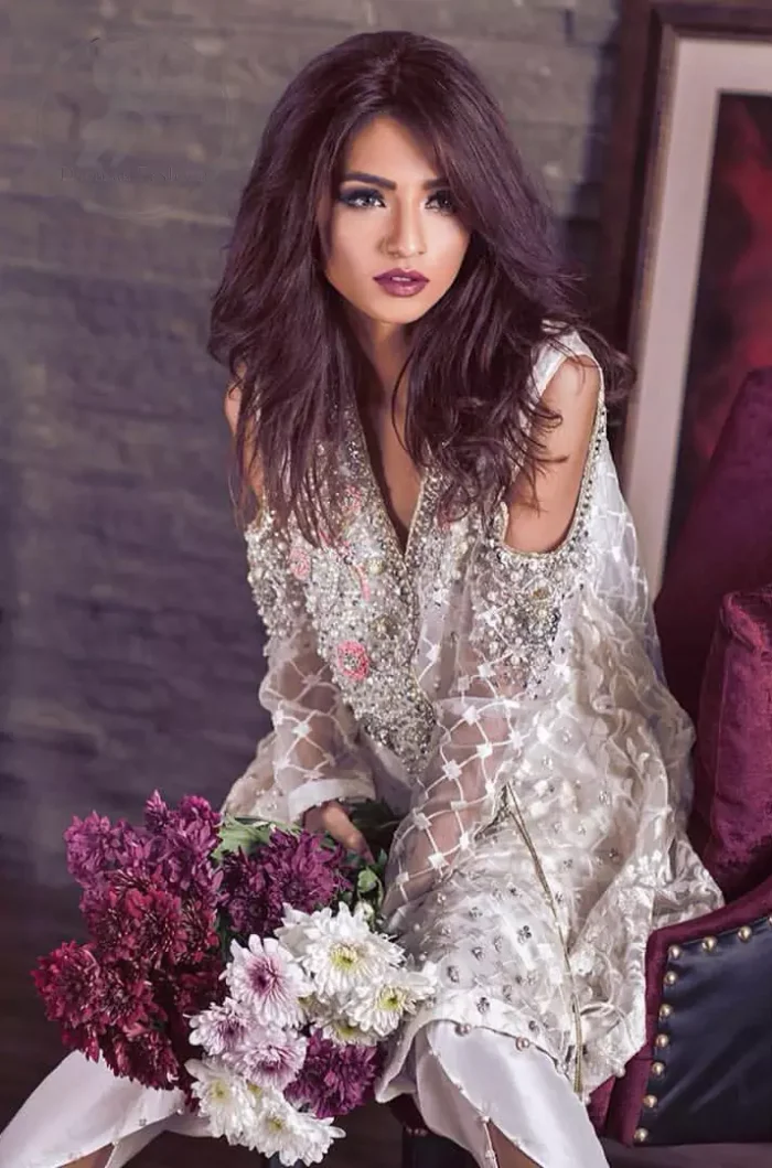 This beautiful angrakha style shirt adorned with embroidered featuring silver and antique shaded kora dabka, tilla, sequins and swarowski. Hemline is decorated with pearls. There is cold shoulder design on sleeves which adds to the look. It comes with brocade pajama.It is coordinated with net dupatta having sprinkled sequins all over it.