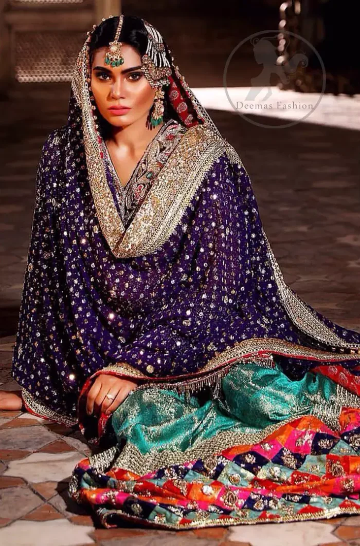 This unique bridal dress is beautifully sculptured with floral thread embroidery. It is meticulously highlighted with silver and antique kora dabka, tilla, sequins and pearls. It is artistically paired up with brocade gharara which is embellished with different color applique. It comes with chiffon dupatta which has four sided embellished border and sprinkled with sequins all over it.