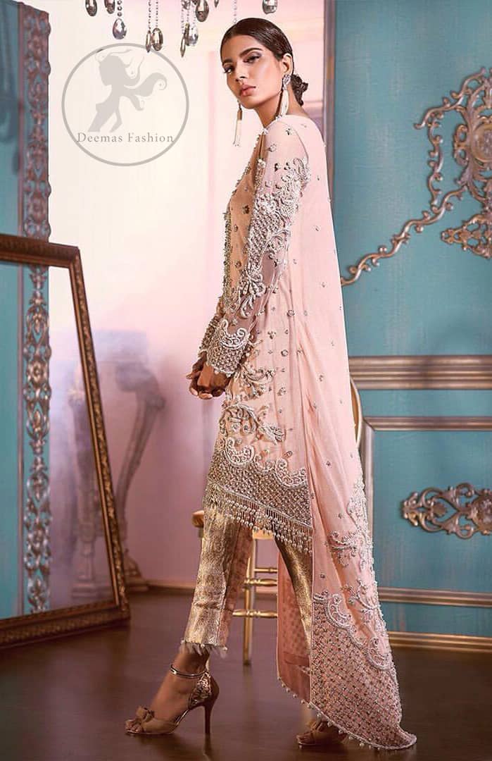 This outfit is decorated with silver kora, dabka, tilla, sequins and pearls. This dress is embellished with floral embroidery and intricate embroidered hemline. It is adorned with beautiful tassels which adds to the look. Sleeves are fully embellished. Trail is also embellished. It comes with brocade pajama. It is coordinated with chiffon dupatta which is sprinkled with sequins all over it.
