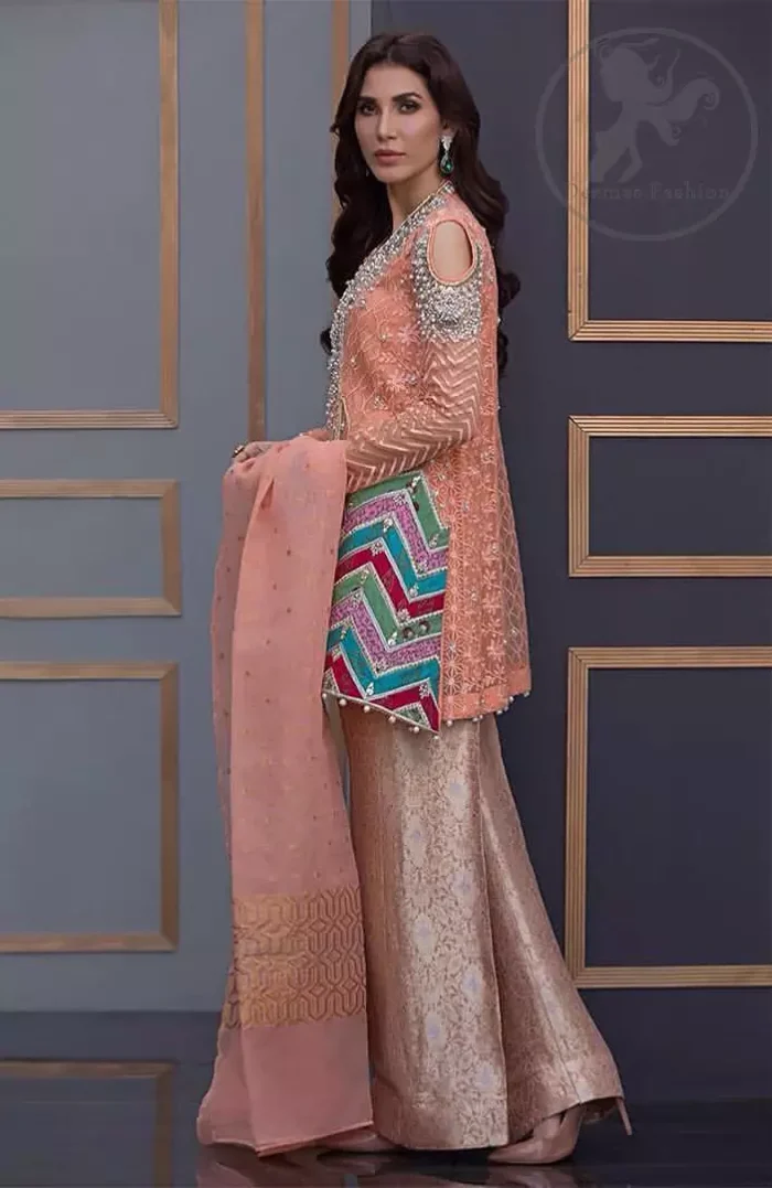 This beautiful self embroidered angrakha embellished with floral thread embroidery. This shirt is decorated with kora, tilla, dabka, swarovsky and sequins. It is allured with cold shoulder sleeves. Daaman of the shirt is decorated with different colour zik zak brocade applique which adds to the look. It is beautifully paired up with brocade trousers.It comes with organza dupatta.