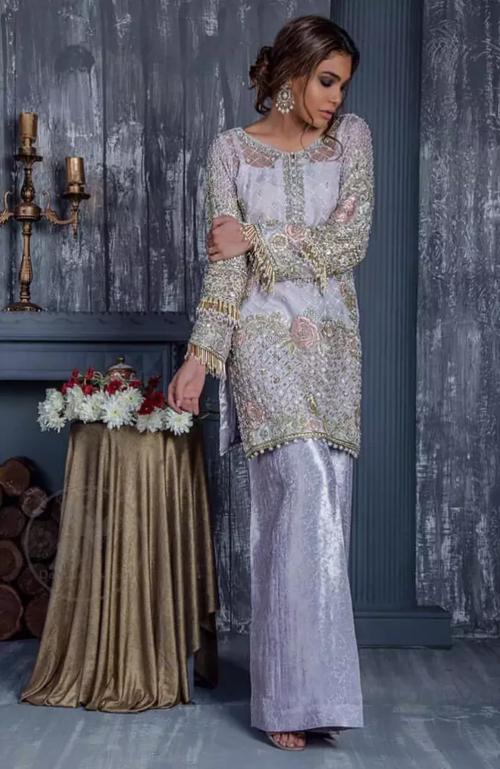 Standout in this gorgeous chiffon shirt embellished with tilla, kora dabka, sequins and pearls.It is further enhanced with floral thread embroidery.Its hemline and sleeves are beautifully decorated with golden tassels.It is beautifully coordinated with self print jacquard trousers. It comes out with chiffon dupatta decorated with sequins spray all over .