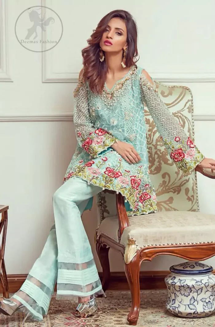 This outstanding self embroidered short frock embellished with floral thread embroidery. It is allured with resham kora dabka tilla and pearls. Sleeves are decorated with cold shoulders design and floral embroidery. Scalloped hemline ornamented with tassels. It is beautifully paired up with matching bell bottom trouser. It comes with light blue dupatta sprinkled with sequins all over it.