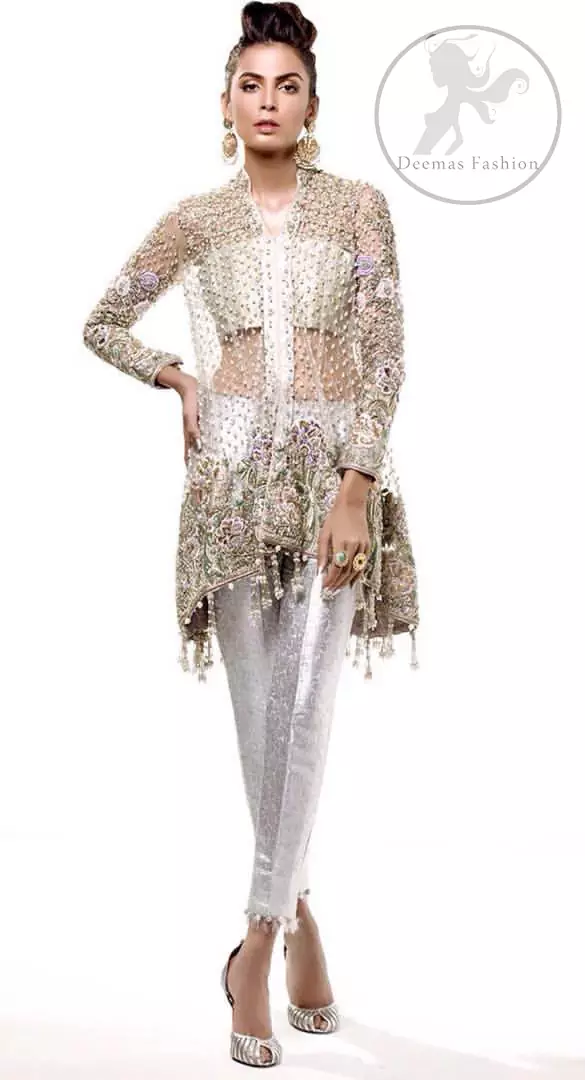 This classic outfit meticulously highlighted with silver golden kora, dabka ,tilla, sequins and pearls. This dress is beautifully sculptured with floral embroidery. The shirt is decorated with tassels and floral motifs on hemline which adds to the look. It comes with brocade pajama and beautifully decorated with net dupatta having sprinkled sequins all over it.