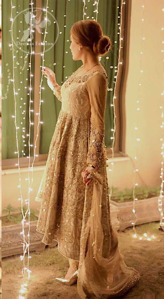 Delicately crafted and personifying chic elegance with an element of grandiose. This pretty gold embroidered frock done with kora dabka, tilla, diamante and sequins. Hemline edges are fully decorated with pearls. It comes with Brocade Pajama and Net dupatta sequins spray all over.