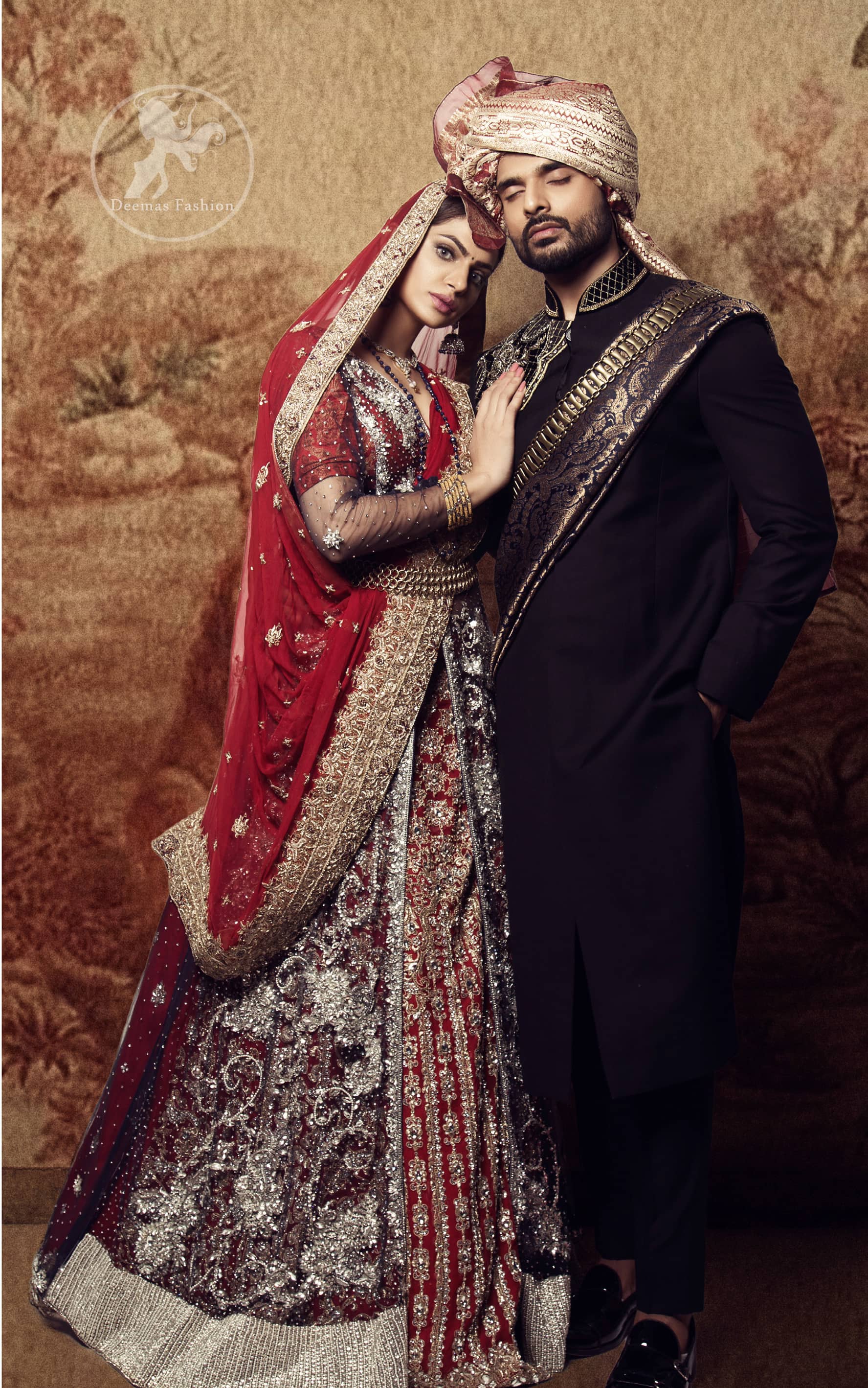 This dress is timeless beauty. Black floor length net paneled gown is beautifully embellished with silver kora dabka, tilla, pearls and sprinkled sequins all over. It comprises with maroon blouse and skirt. The skirt is ornamented with floral motifs done with silver gold kora dabka, tilla, kundan and sequins work. This outfit is coordinated with maroon dupatta with embroidered borders on all four sides and sequins work on the ground.