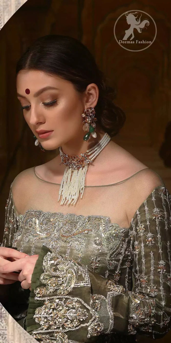 The beautiful bodice is decorated with intricate stones and sequins. It is further enhanced with vertical lines and floral motifs done with kora dabka, tilla, sequins and colorful thread work. Paired up with embroidered bell bottom. This outfit is beautifully coordinated with olive green dupatta with embellished borders on sides and sprinkled sequins.
