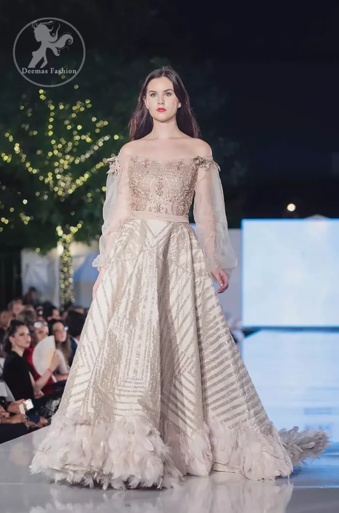 This dress is timeless beauty. The sweetheart neckline is decorated with intricate stones and sequins. Antique shaded kora dabka enhanced the beauty of bodice. Off shoulder sleeves enhanced the beauty of this maxi. Waist belt add to the look. It is paired up with antique white churidar pajama.