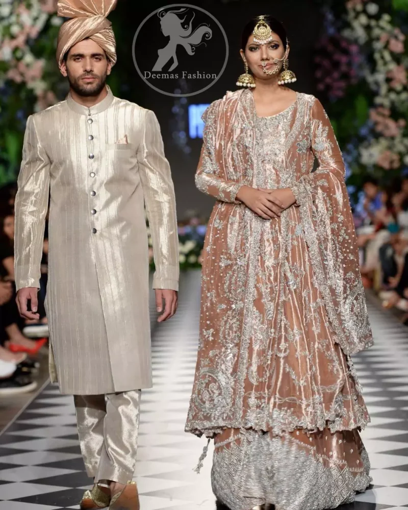 This dress is beautifully decorated with heavy embroidery. It is highlighted with kora, dabka, tilla, sequins and pearls. It comes with embroidered sharara. It is coordinated with tissue dupatta which is sprinkled with sequins all over it. It is further furnished with four sided scalloped border.