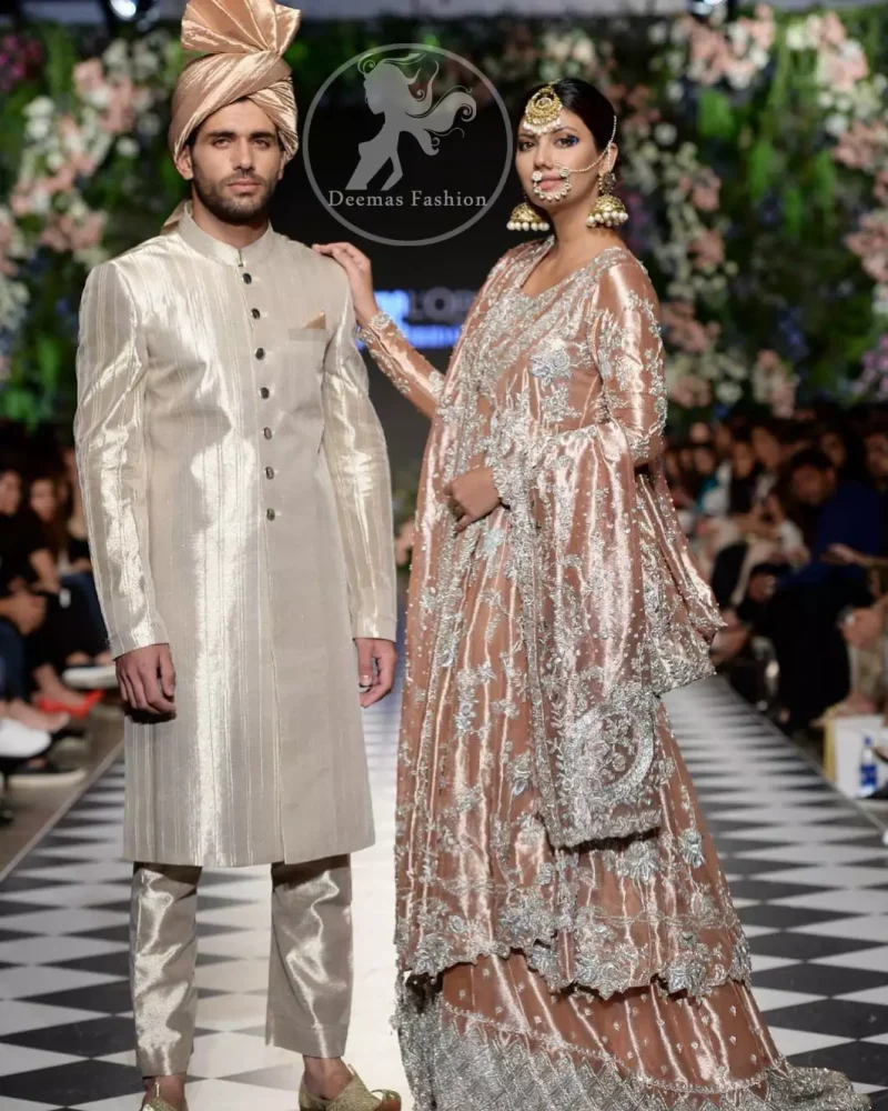 This dress is beautifully decorated with heavy embroidery. It is highlighted with kora, dabka, tilla, sequins and pearls. It comes with embroidered sharara. It is coordinated with tissue dupatta which is sprinkled with sequins all over it. It is further furnished with four sided scalloped border.