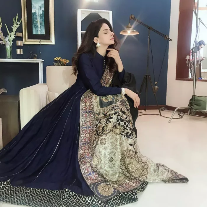 Look alluring in this floor length frock embellished with kora, dabka, tilla, sequins and pearls. The border on the daman is enhanced with embellished floral pattern, detailing that instantly draws attention. It comes with matching cigarette pants. Multiple panels adds to the look. It is paired up with embroidered shawl with sequins sprinkled and finished with light embroidered edges.