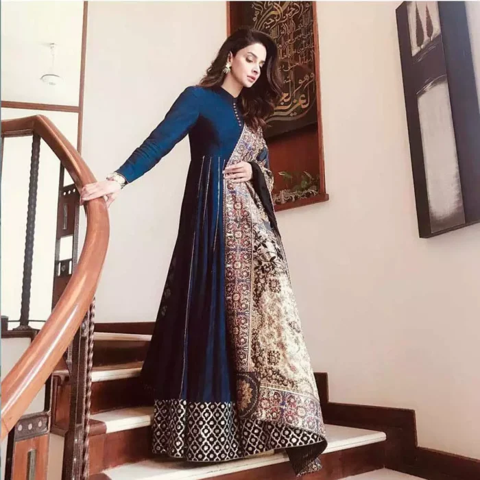 Look alluring in this floor length frock embellished with kora, dabka, tilla, sequins and pearls. The border on the daman is enhanced with embellished floral pattern, detailing that instantly draws attention. It comes with matching cigarette pants. Multiple panels adds to the look. It is paired up with embroidered shawl with sequins sprinkled and finished with light embroidered edges.