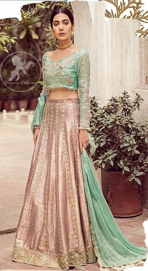 The bridal stands out due to its uniqueness and the perfect fusion of modern cut and traditional embroidery. This dress is beautifully decorated with heavy embroidery. It is highlighted with dull golden kora, dabka, tilla, sequins, pearls and thread embroidery. This outfit comes with salmon pink lehenga which is enhanced with embroidery on bottom. It is coordinated with tissue dupatta which is sprinkled with sequins all over it. It is further furnished with four sided scalloped border.