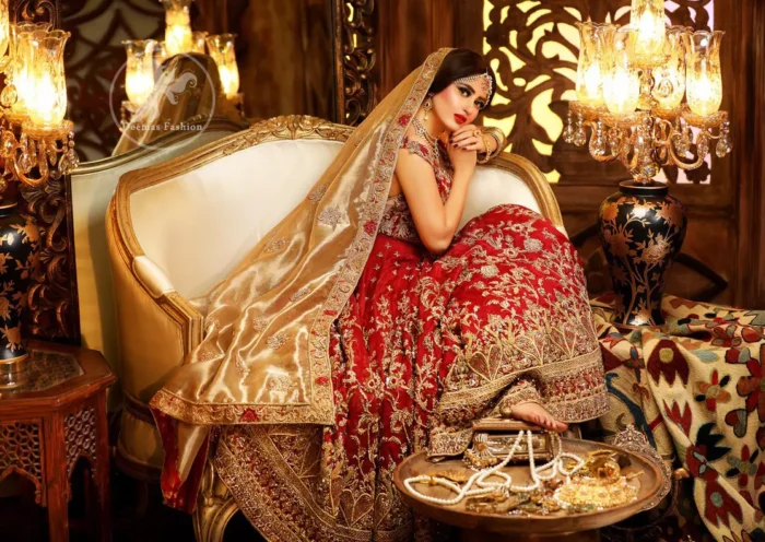Reflecting royalty and the majestic beauty of statuesque shape and silhouette this bridal dress is perfect for your special day. Feel glamorous in this floor length maxi with fascinating embellishment around the neckline with golden kora dabka, pearls and sequins. It is further enhanced with floral motifs and heavy embroidered bottom. The hemline is decorated with heart shape motifs all around the bottom of maxi. It comprises with brocade pajama and golden dupatta having four sided embroidered borders and sprinkled small motifs on ground.
