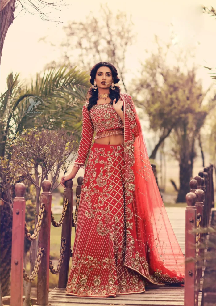 Boost your confidence and style in this glamorous blouse skirt with finest embroidery. The blouse is ornamented with light gold kora dabka, kundan and sequins work, elaborate it with tassels. The skirt is meticulously designed with vintage styled frames. It is further enhanced with light embroidered border along floral embroidery and zerdozi work. This outfit is coordinated with red dupatta with embroidered borders on all four sides and sprinkled sequins on the ground.