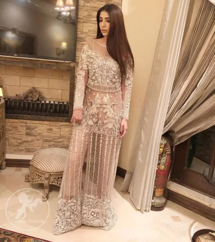 Exude elegance and class in this shirt finessed with beautiful embellished daaman. This dress is beautifully decorated with heavy embroidery. It is highlighted with silver kora, dabka, tilla, sequins and pearls. Bodice is ornamented with heavy embellishment and addition of tassels to complete the look. It comes with matching capri. It is coordinated with chiffon dupatta which is sprinkled with sequins all over it.