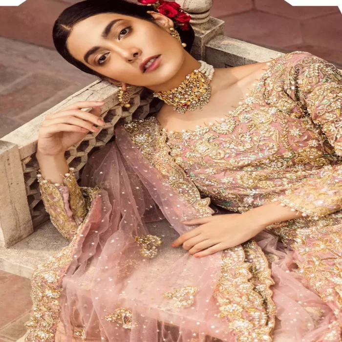 The grand gold bridal stands out due to its uniqueness and the perfect fusion of modern cut and traditional embroidery. It is highlighted with dull golden and silver kora, dabka, tilla, sequins and pearls. The frock is fully embellished from daman. It is coordinated with matching lehenga which has sprinkled floral motifs. This outfit is paired up with net dupatta which is sprinkled with sequins and small floral motifs. It is furthermore enhanced with four sided scalloped border.