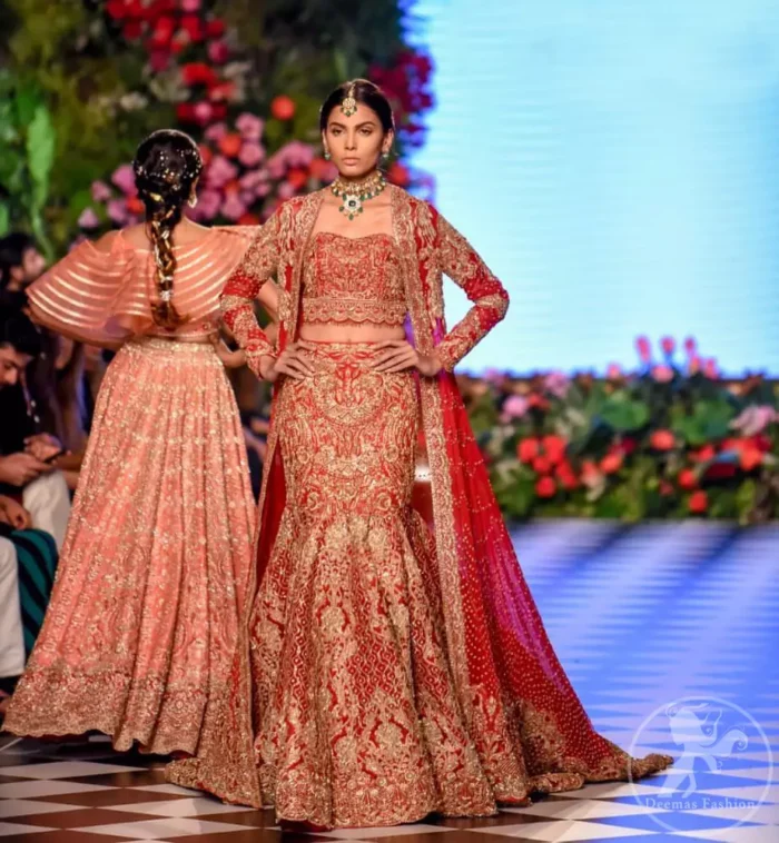 This dress is beautifully decorated with heavy embroidery. It is highlighted with dull golden kora, dabka, tilla, sequins and pearls. Fish lehengha is fully embellished.Blouse is scalloped. It comes with beautifull upper gown, sprinkled with sequins all over it. It is coordinated with chiffon dupatta which is sprinkled with sequins all over it.