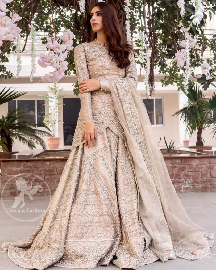 This outfit is adorned with kora, dabka, tilla, sequins and pearls. It is decorated with floral embellishments. It is overlapping shirt which adds to the look. It comes with heavy embellished lehengha allured with geometrical pattern all over it which has thick border on hemline. Tissue dupatta accompanies the garment. The dupatta has embellished borders on all four sides and small floral motifs all over it. The garment is lined with medium silk.
